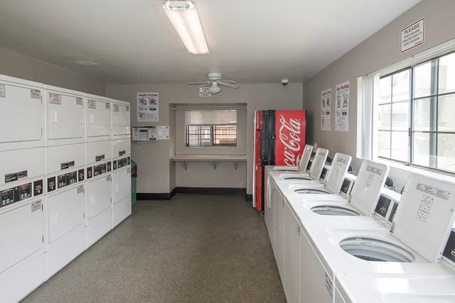 Laundry room with multiple washing machines and dryers.
