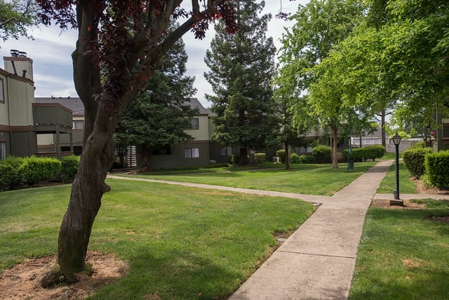 Apartment buildings with manicured lawns and walking paths.