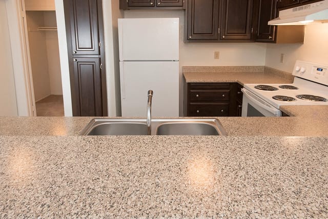 Kitchen with double sink, refrigerator, and stove.