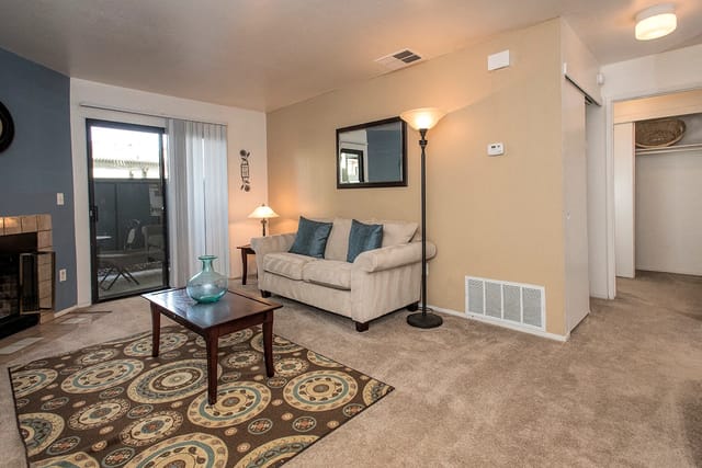 Living room with sofa, coffee table, and fireplace.