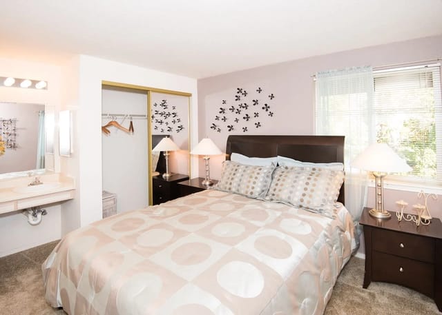 Bedroom with a queen-size bed, nightstands, closet, and vanity.