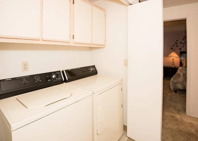 In-unit washer and dryer with overhead cabinets.