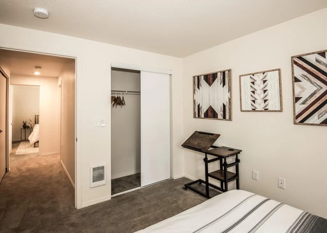 Bedroom with a closet and decorative wall art.