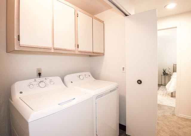 In-unit washer and dryer with overhead cabinets.