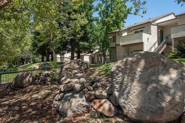 Stone landscaping with apartment buildings in the background.