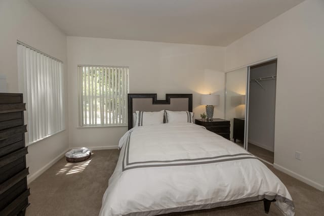 Bedroom with a queen-size bed, nightstand, dresser, and closet.