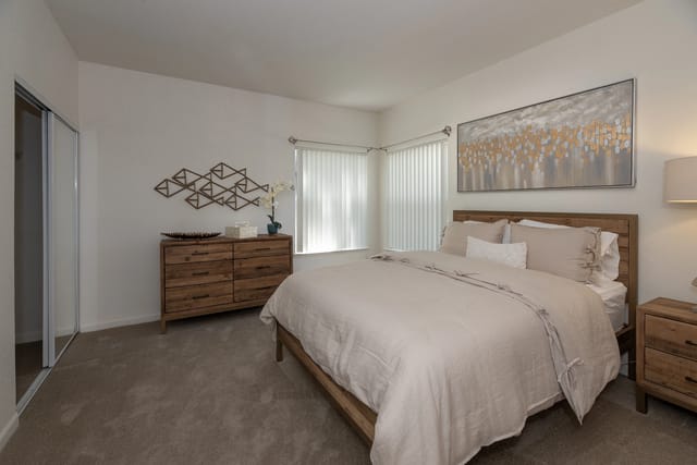 Bedroom with a king-size bed, dresser, and closet.