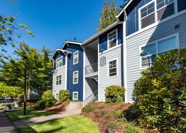 Exterior building view of apartment complex with blue and grey siding.
