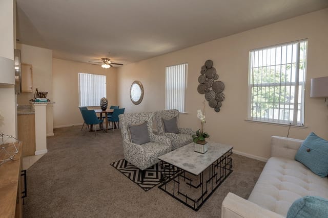 Living and dining area with a sofa, two chairs, a coffee table, and a dining table.