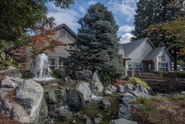 Exterior building entrance with a rock waterfall and stream.