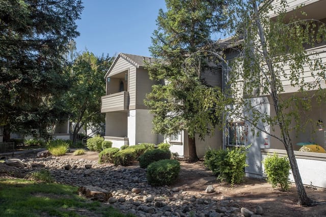 Exterior view of apartment buildings with balconies and lush greenery.