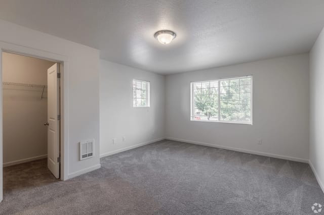 Bedroom with closet and two windows
