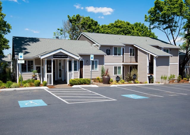 Leasing office entrance and building exterior with parking lot.