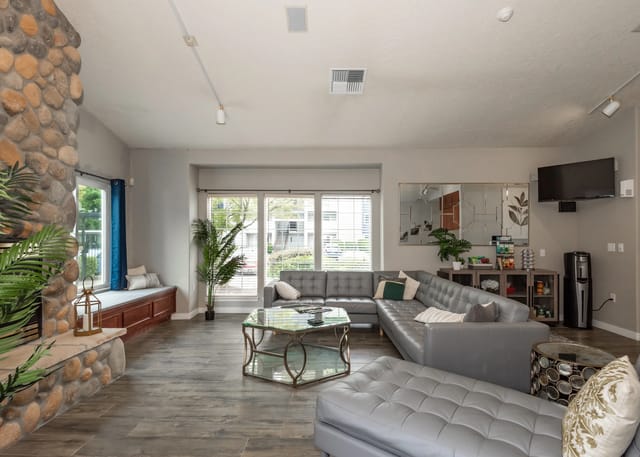 Living room with a large sectional sofa, stone fireplace, and large windows.