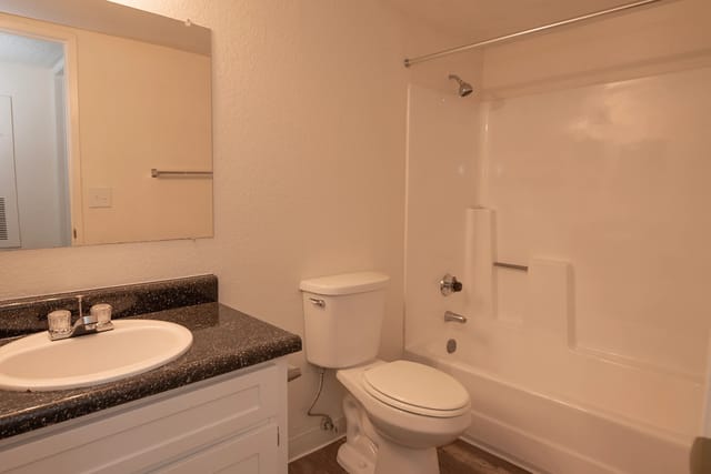 Bathroom with a vanity, sink, toilet, and shower/tub combo.