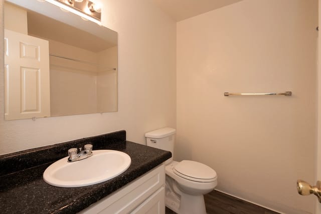 Bathroom with vanity, sink, toilet, and shower.