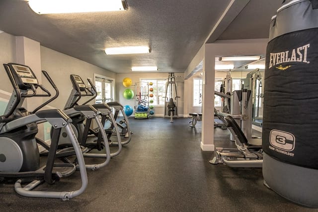 Fitness center with cardio machines, weight training equipment, and a punching bag.