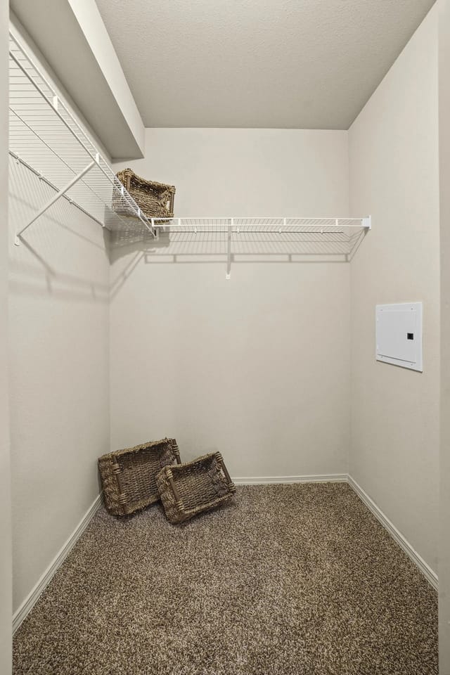 Empty walk-in closet with wire shelving and baskets.