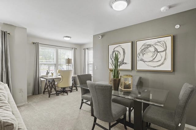 Dining area with glass table and chairs, and a home office desk with chair.