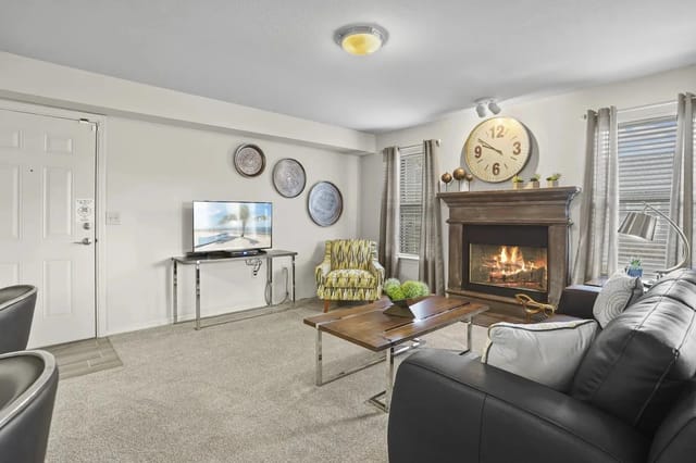 Cozy apartment living room with a fireplace, sofa, and TV.