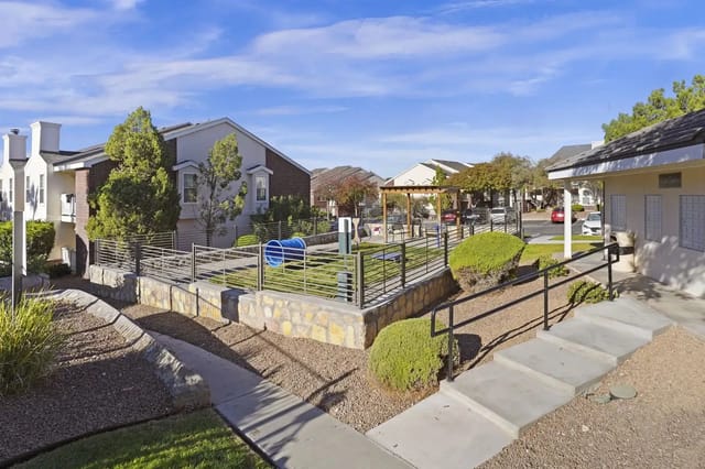 Exterior view of a multifamily community courtyard with landscaped paths, stairs, and railings.