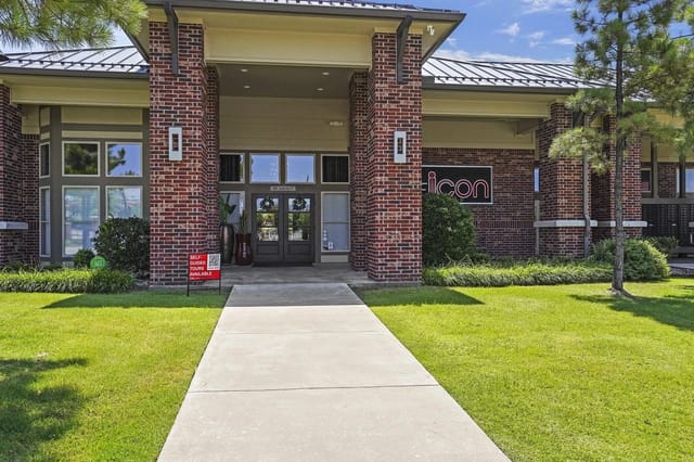 The exterior entrance of the Icon apartment complex with a walkway leading to the front doors.