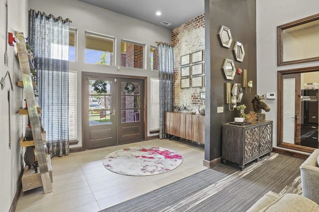 Interior view of a multifamily property's grand entrance with double doors, large windows, and decorative elements.