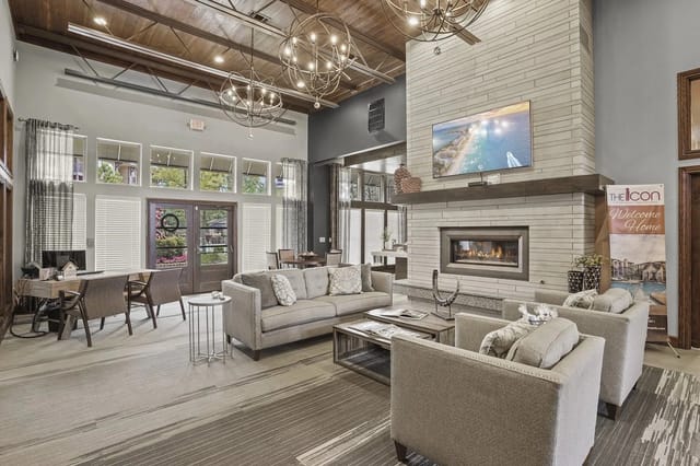 Modern lounge area with a fireplace, comfortable seating, and large windows.