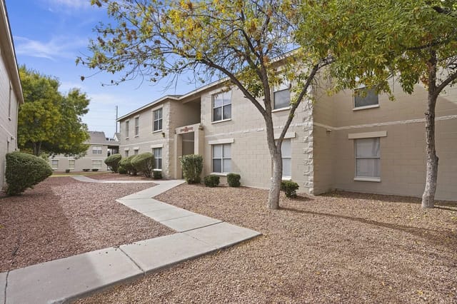 Exterior of apartment buildings with walkways and trees.