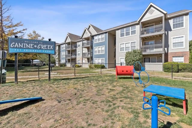 Exterior view of Canine Creek apartments with a pet-friendly playground.