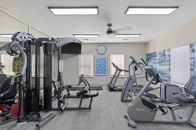 Fitness center in an apartment community with cardio machines and weight equipment.