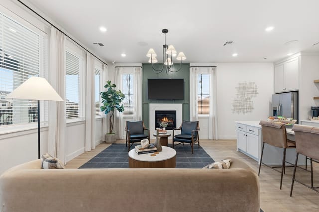 Living room with fireplace, TV, seating, and kitchen island.