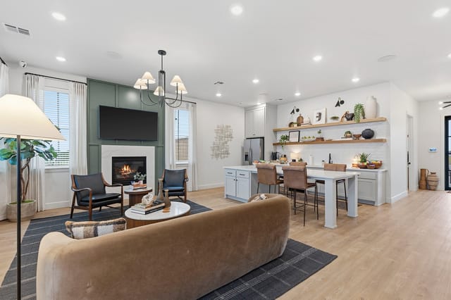 Living room and kitchen area with fireplace, TV, island, and dining table.