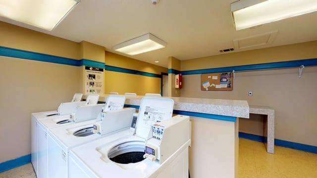 Laundry room with multiple washing machines and dryers.