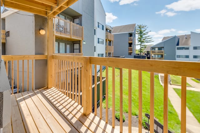 Balcony view of apartment buildings with green grass and walkways.