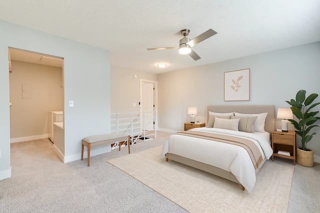 Bedroom with a king-size bed, nightstands, a bench, and a ceiling fan.