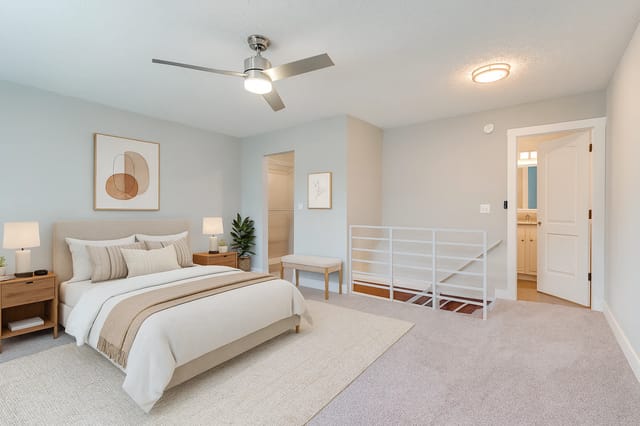 Bedroom with a king-size bed, nightstands, ceiling fan, and access to a bathroom.
