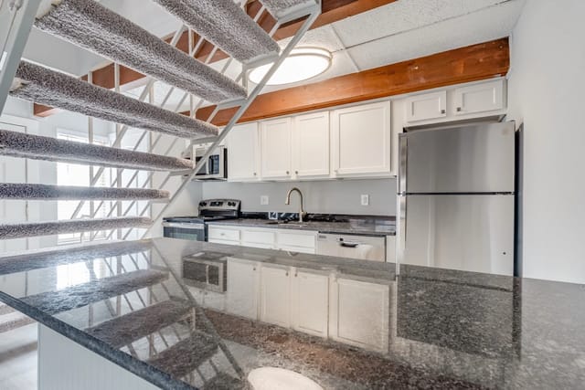Kitchen with granite countertops, stainless steel appliances, and a breakfast bar.