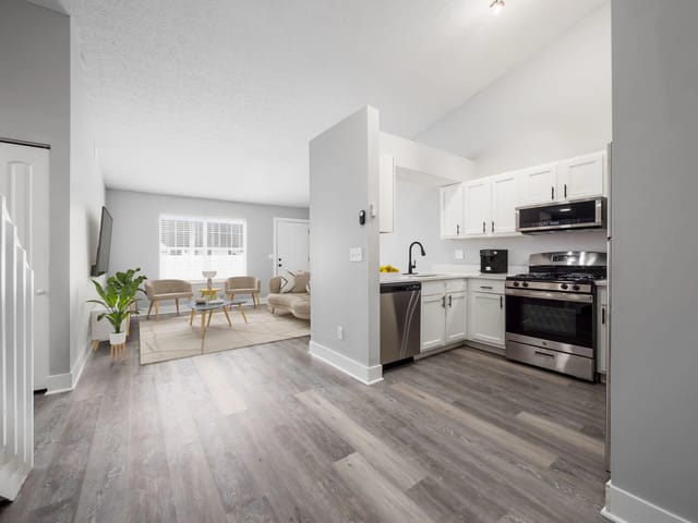 Open concept living and kitchen area with stainless steel appliances and modern finishes.