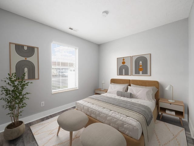Modern bedroom with a queen-size bed, bedside tables, and minimalist art.