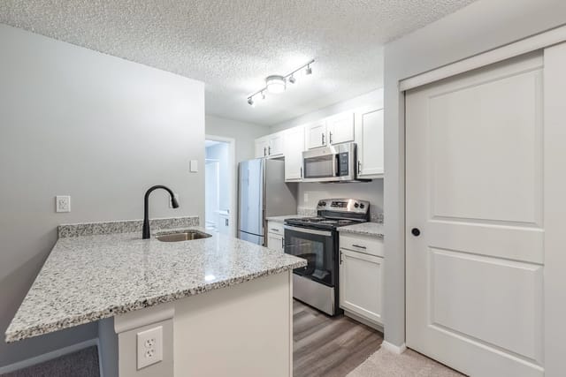 Modern kitchen with granite countertops and stainless steel appliances.