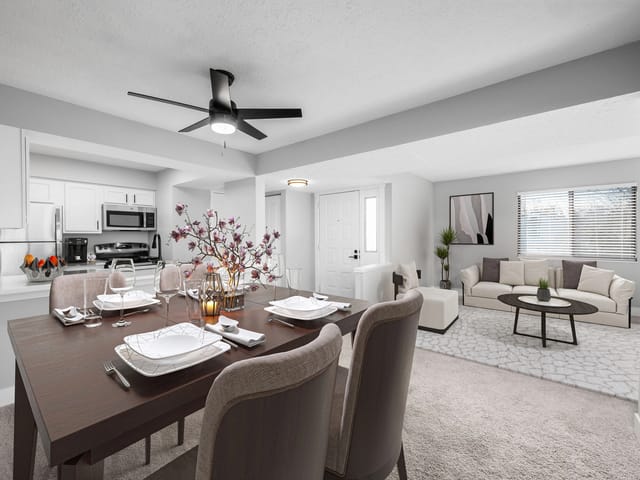Dining area and living room with a kitchen in the background.