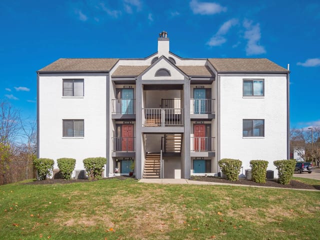 Exterior of a multifamily apartment building with multiple entrances and balconies.