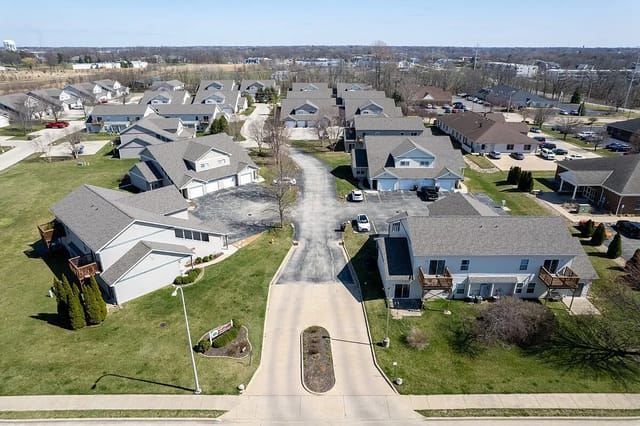 Aerial view of a multifamily property with multiple buildings and a central road.