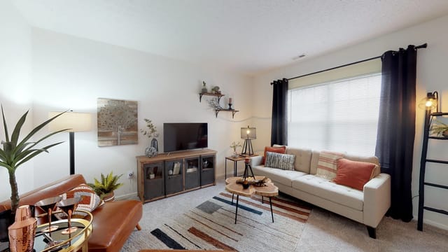 Living room with a sofa, accent chair, TV stand, and coffee table.