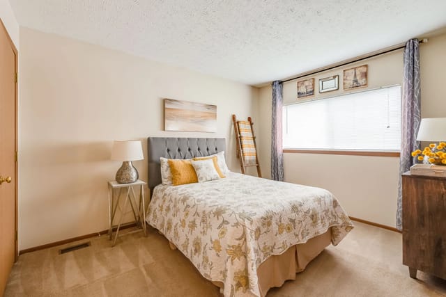 Cozy bedroom with a queen-sized bed, nightstand, and dresser.