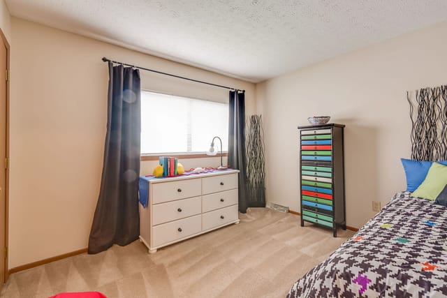 Bedroom with a dresser, window, and a bed.
