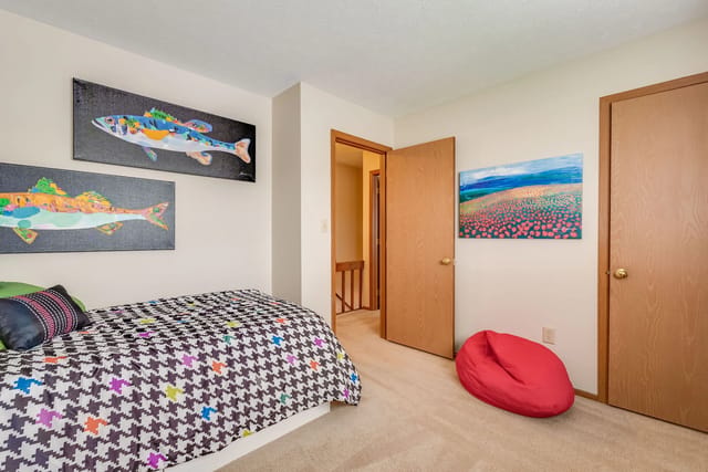 Bedroom with houndstooth bedding, fish art, and a red beanbag chair.