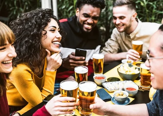 Round dining table with banquette seating, overlooking windows and a desk area.