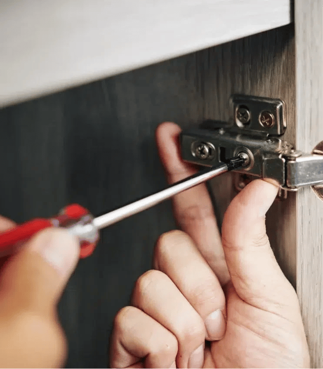 Living room with a large TV and a kitchen island with bar stools.